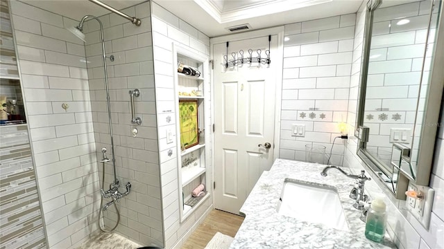 bathroom featuring vanity, tiled shower, hardwood / wood-style floors, and crown molding