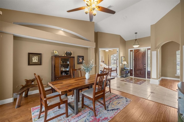 tiled dining space with plenty of natural light, lofted ceiling, and ceiling fan