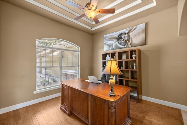 office with ceiling fan, light hardwood / wood-style floors, ornamental molding, and a tray ceiling