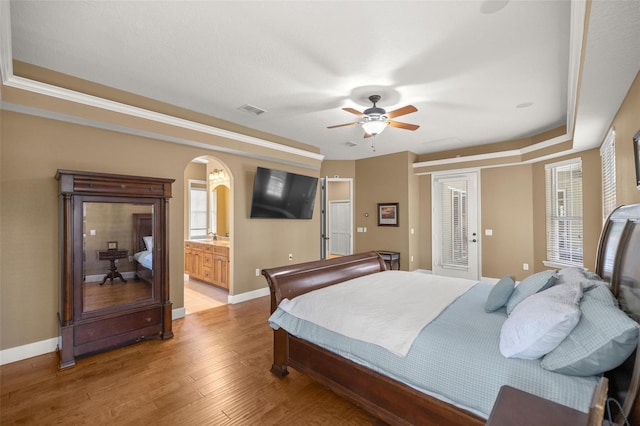 bedroom featuring light hardwood / wood-style flooring, ensuite bath, and ceiling fan