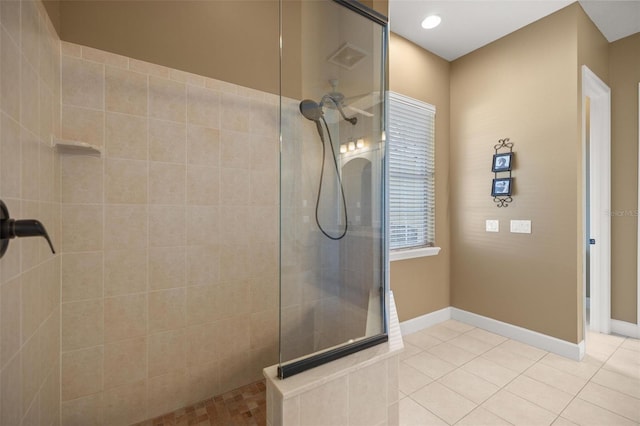 bathroom with a tile shower and tile patterned flooring