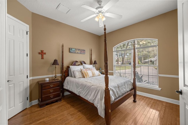 bedroom with multiple windows, a textured ceiling, light hardwood / wood-style flooring, and ceiling fan