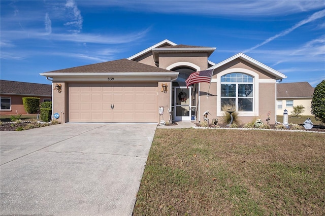 single story home with a garage and a front lawn