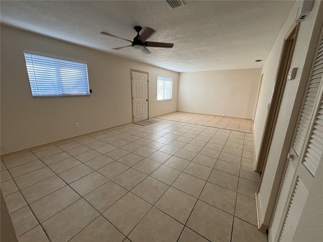 tiled spare room featuring a textured ceiling and ceiling fan