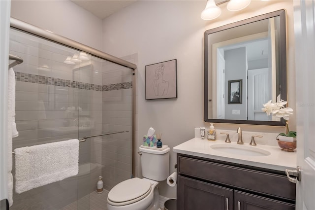 bathroom featuring an enclosed shower, vanity, and toilet