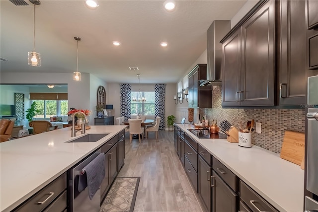 kitchen with backsplash, stainless steel dishwasher, black electric cooktop, sink, and pendant lighting