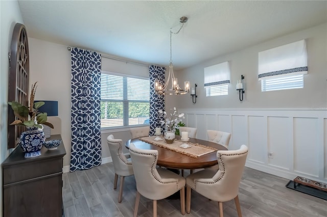 dining room with light hardwood / wood-style flooring and a notable chandelier