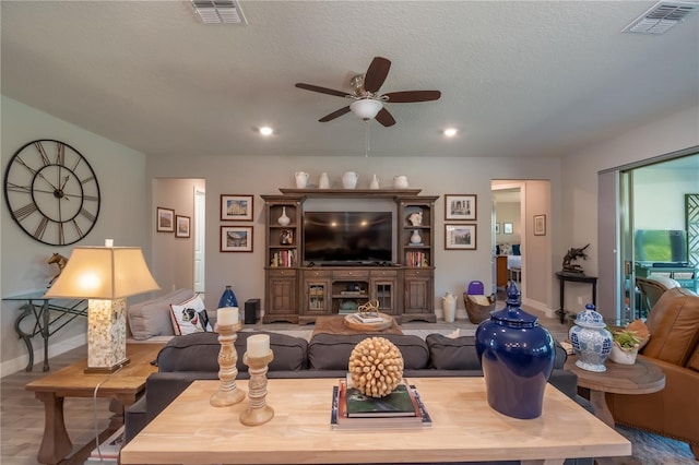 living room with ceiling fan, a textured ceiling, and hardwood / wood-style flooring