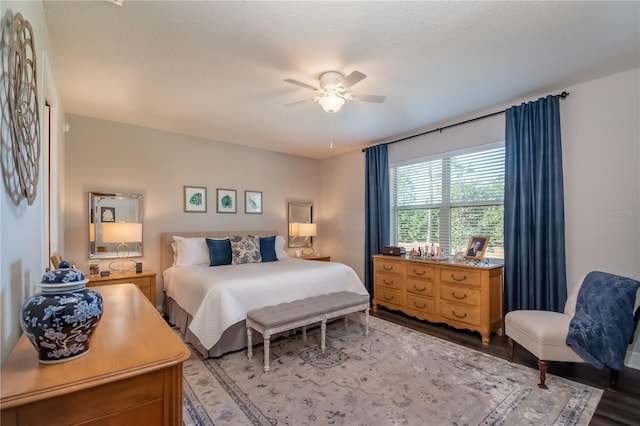 bedroom with a textured ceiling, light wood-type flooring, and ceiling fan