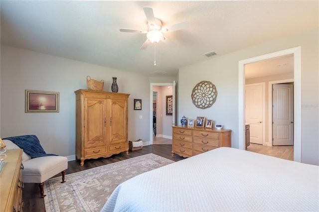 bedroom with connected bathroom, ceiling fan, and dark hardwood / wood-style floors