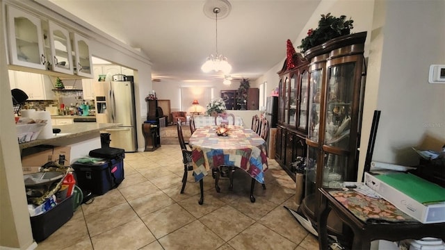 dining area featuring ceiling fan with notable chandelier and light tile patterned floors