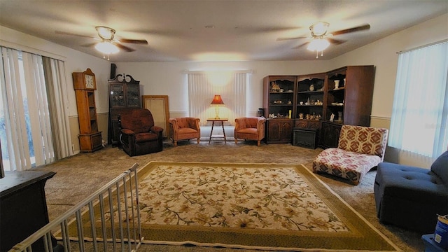 sitting room with ceiling fan and carpet flooring