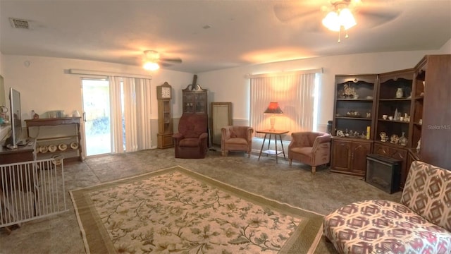 sitting room with a ceiling fan, visible vents, and carpet flooring