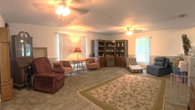 living room featuring ceiling fan, visible vents, and carpet flooring