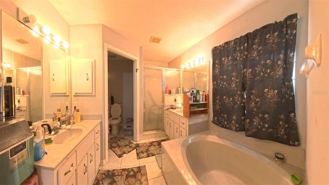 bathroom featuring a stall shower, toilet, tile patterned floors, vanity, and a bath