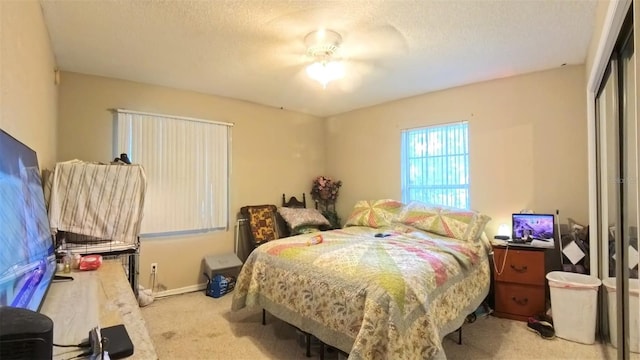 carpeted bedroom featuring a textured ceiling, a closet, and baseboards