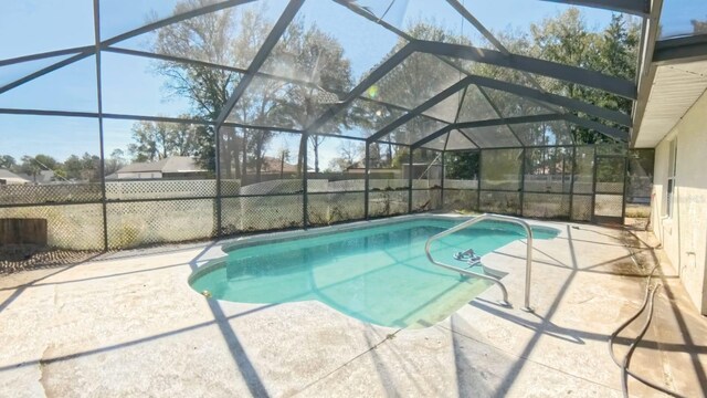 view of pool with glass enclosure, a patio area, fence, and a fenced in pool