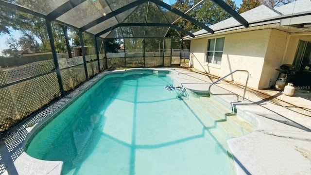 pool featuring a patio, fence, and a lanai