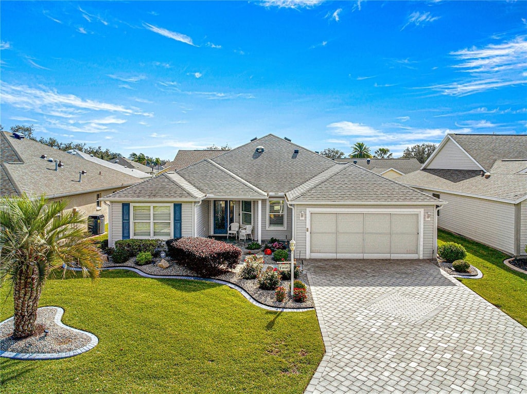 single story home with a garage and a front lawn