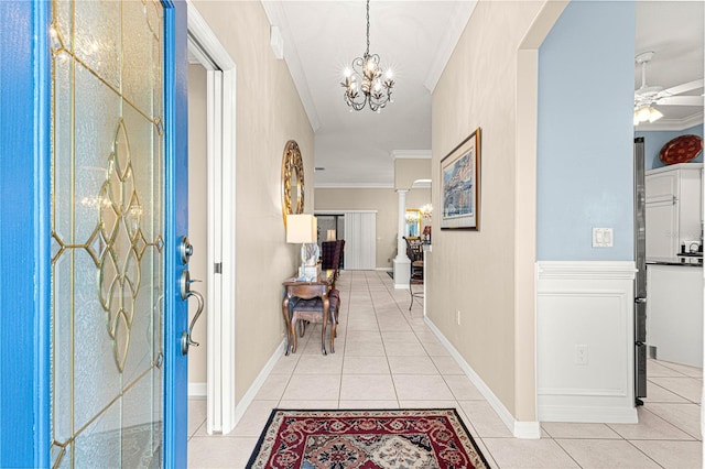 hall with crown molding, light tile patterned floors, and a notable chandelier