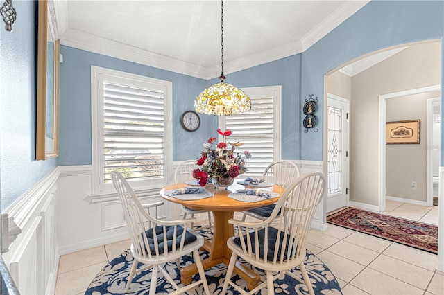 dining space featuring a notable chandelier, light tile patterned flooring, and crown molding