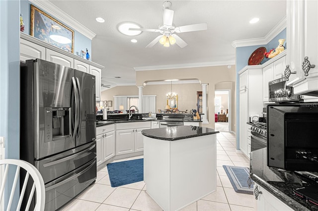 kitchen with kitchen peninsula, appliances with stainless steel finishes, ornamental molding, light tile patterned floors, and white cabinetry