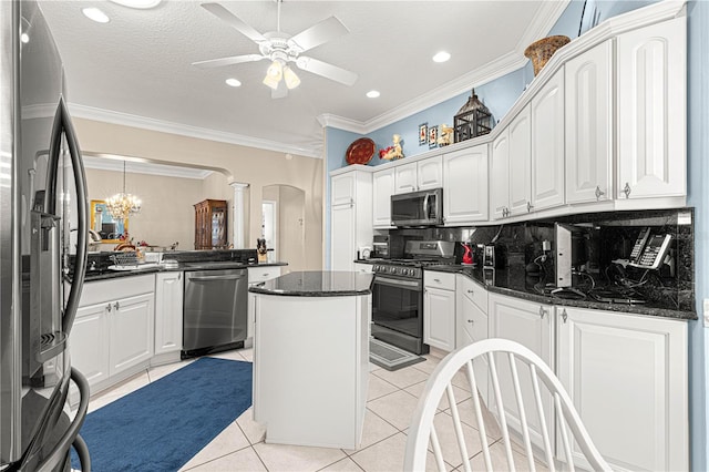 kitchen with a center island, light tile patterned floors, appliances with stainless steel finishes, tasteful backsplash, and white cabinetry