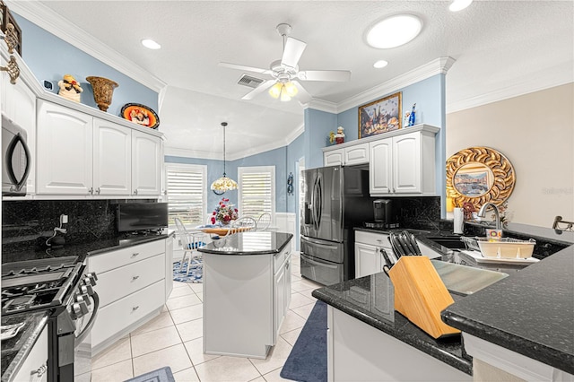 kitchen featuring a center island, backsplash, vaulted ceiling, appliances with stainless steel finishes, and white cabinetry