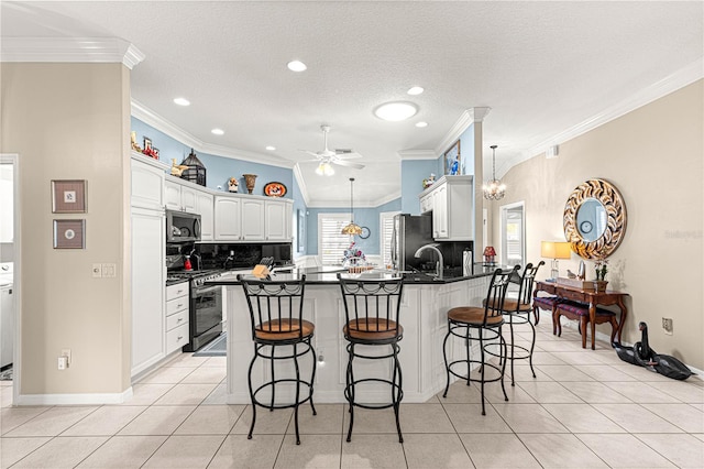 kitchen with appliances with stainless steel finishes, a kitchen breakfast bar, tasteful backsplash, crown molding, and white cabinets