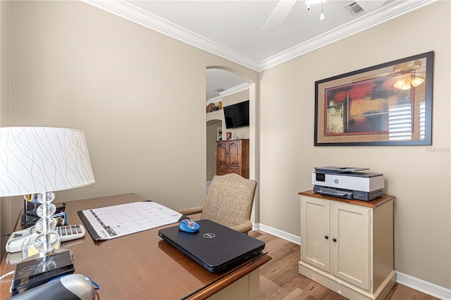 office space featuring crown molding, light hardwood / wood-style flooring, ceiling fan, and a textured ceiling