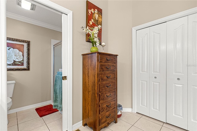 bathroom with tile patterned floors, toilet, walk in shower, and ornamental molding