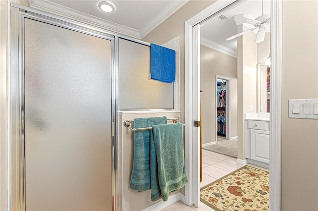 bathroom with tile patterned floors, a shower with door, and ornamental molding