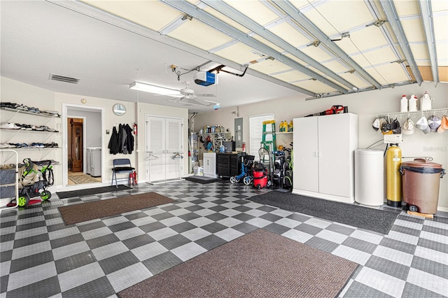 garage with gas water heater, electric panel, a garage door opener, and ceiling fan