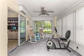 workout area featuring ceiling fan and a wall unit AC