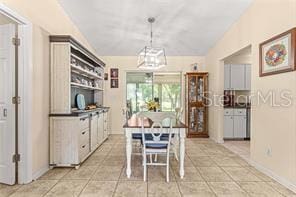 kitchen featuring light tile patterned floors, decorative light fixtures, and vaulted ceiling