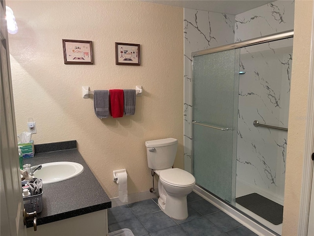 bathroom with tile patterned flooring, vanity, toilet, and walk in shower