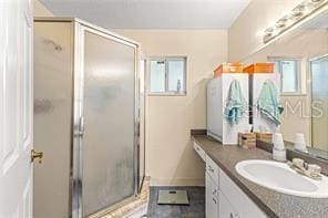 bathroom with a wealth of natural light, vanity, and walk in shower