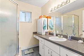 bathroom with vanity and a shower with door