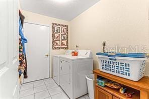 laundry area with light tile patterned floors and independent washer and dryer