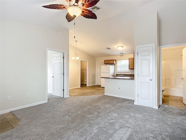 unfurnished living room with ceiling fan with notable chandelier, sink, light carpet, and vaulted ceiling