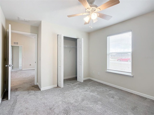 unfurnished bedroom featuring ceiling fan, a closet, and light colored carpet