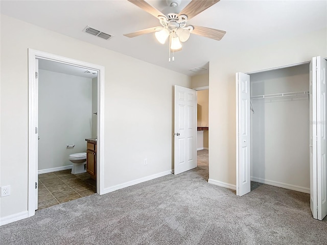 unfurnished bedroom with ensuite bath, ceiling fan, a closet, and light colored carpet