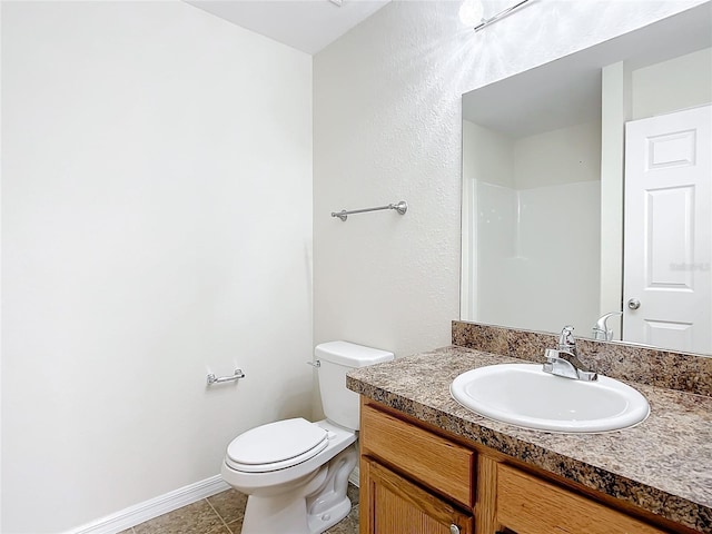 bathroom featuring tile patterned floors, walk in shower, vanity, and toilet