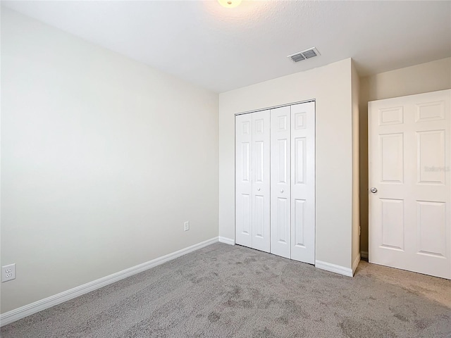 unfurnished bedroom with a closet and carpet floors