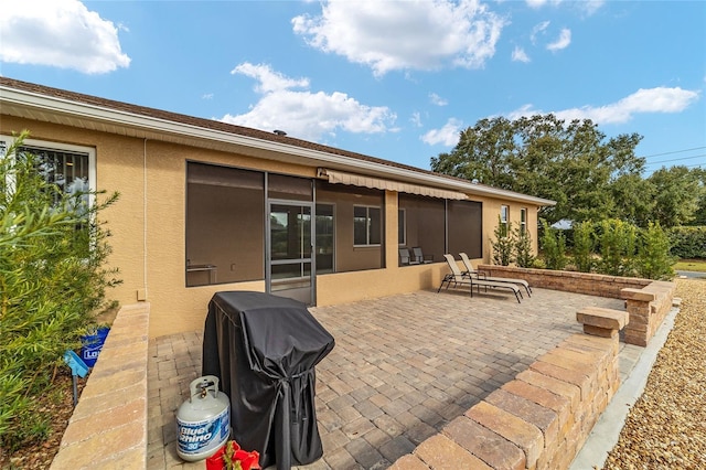 view of patio featuring a grill and a sunroom