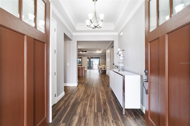 foyer entrance with ceiling fan with notable chandelier, dark hardwood / wood-style flooring, ornamental molding, and a tray ceiling