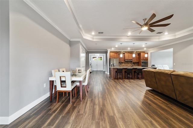 dining area featuring a tray ceiling, crown molding, and ceiling fan