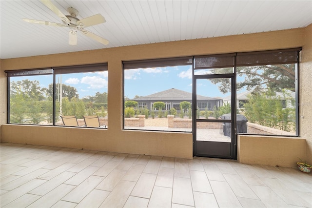 unfurnished sunroom with ceiling fan and a healthy amount of sunlight