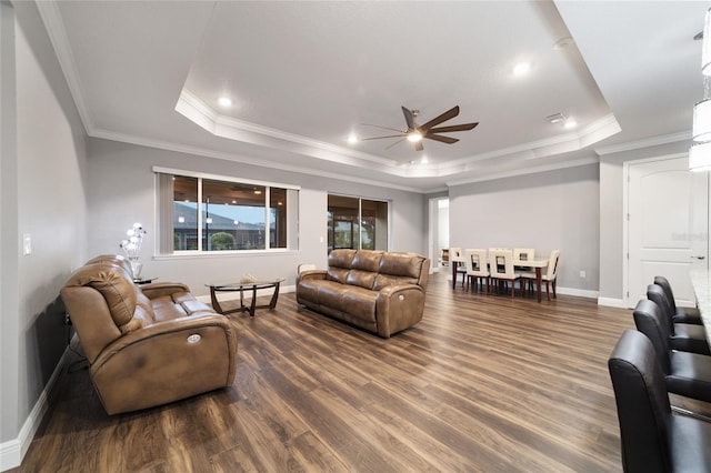 living room featuring a tray ceiling, ceiling fan, and dark hardwood / wood-style floors