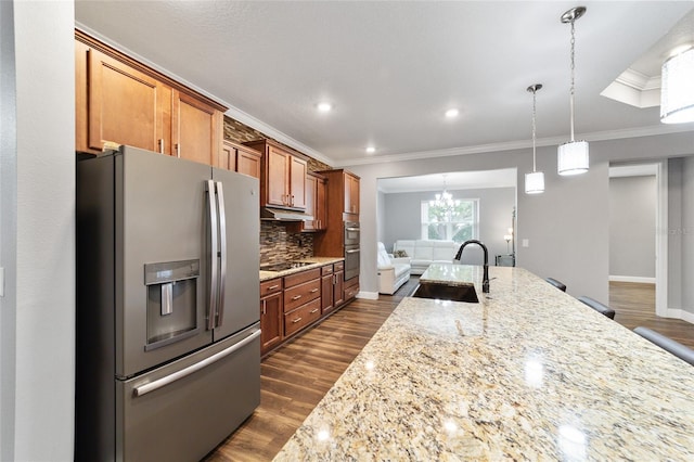 kitchen with decorative backsplash, appliances with stainless steel finishes, light stone counters, and sink